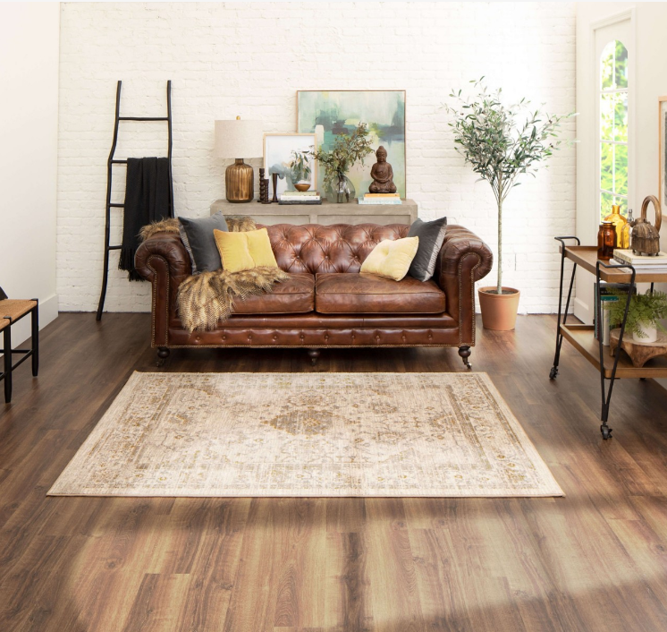 Brown wood-look floors in a bright boho living room complement a leather couch.